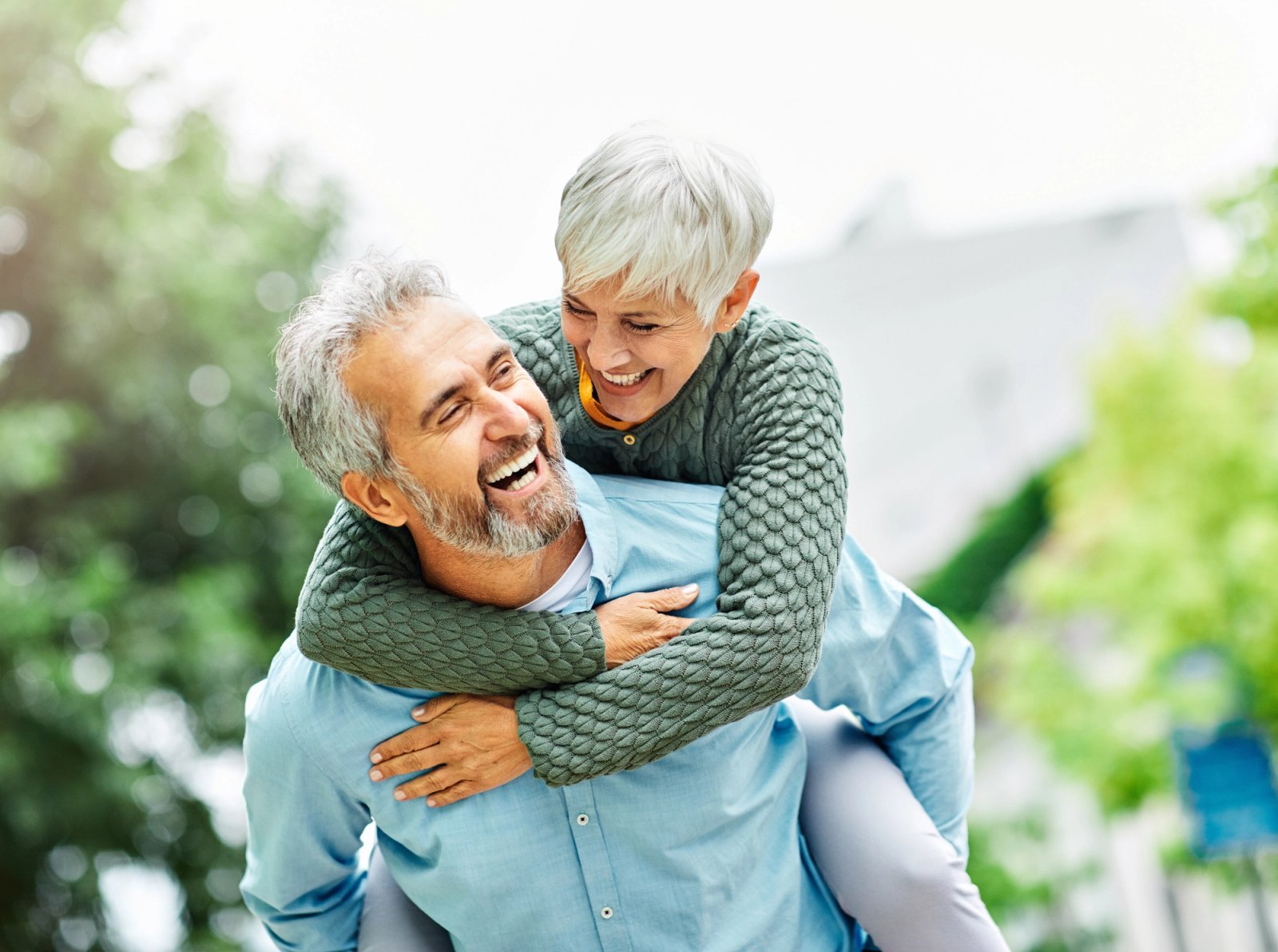 Joyful senior couple laughing during a piggyback ride. Joyful senior couple laughing during a piggyback ride.