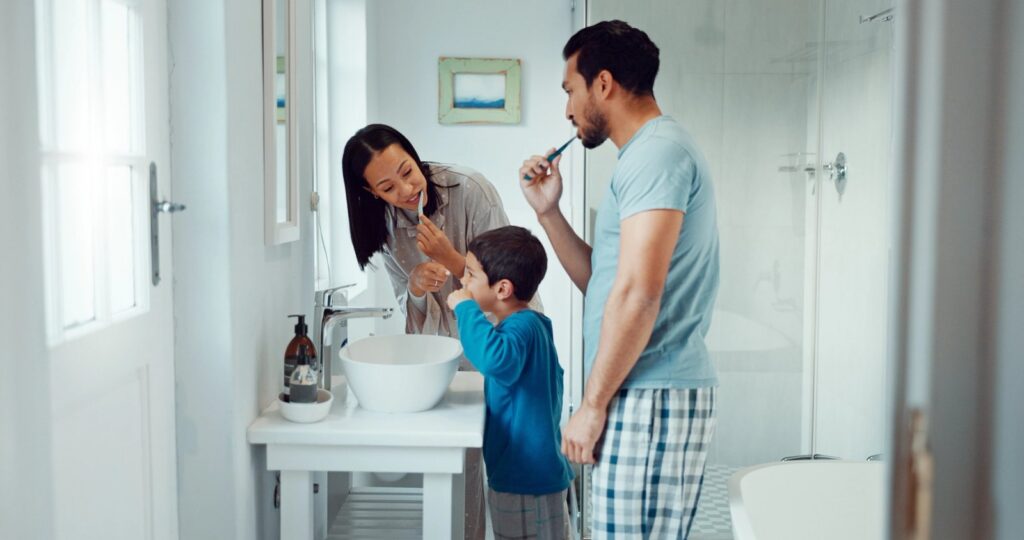 Defeating Dental Decay: Understanding Cavities and How to Prevent Them a family is brushing their teeth together in the bathroom .