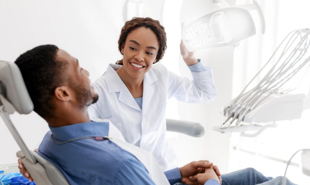 Root Canals: Do I Really Need One? a dentist is talking to a patient in a dental chair .